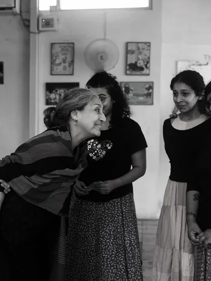 A warm moment of interaction between cast members during a rehearsal.