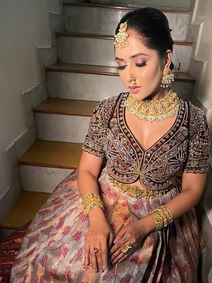 A beautiful portrait of a model in a South Indian half saree. This look combines a printed skirt with a heavily embroidered blouse and a rich maroon dupatta, draped for a perfect finish.