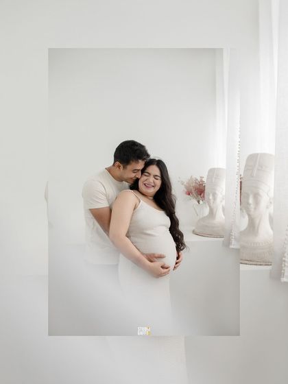 A joyful and candid moment between the expectant couple, filled with laughter and love.