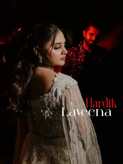 A dramatic Sangeet portrait with the groom out of focus in the background, creating a sense of depth and story.