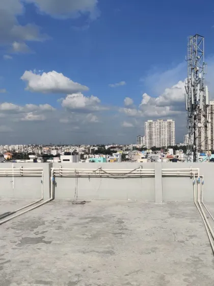 A different perspective of the same empty rooftop, showing the challenges like exposed piping and uneven surfaces that we expertly conceal with our flooring solutions.