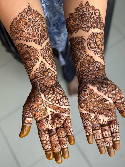 I love how the leaf-shaped blocks create a path of negative space in this design. It guides the eye through the intricate floral and paisley work that covers the hands and arms.