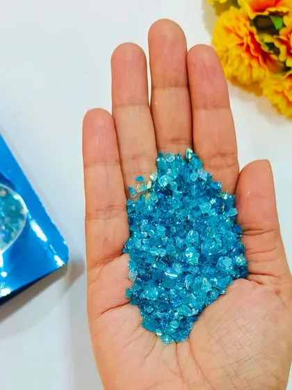 This handful of light blue holographic glass granules shows their brilliant shine. Use them to create stunning ocean effects or add a crystal-like finish to your resin projects.