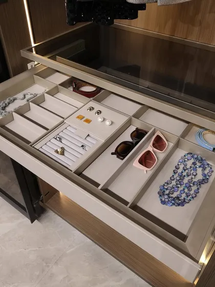 It's the small details that define true luxury. This close-up of a custom accessory drawer shows our commitment to organization. With dedicated, felt-lined compartments for jewelry, sunglasses, and watches, everything has its place.