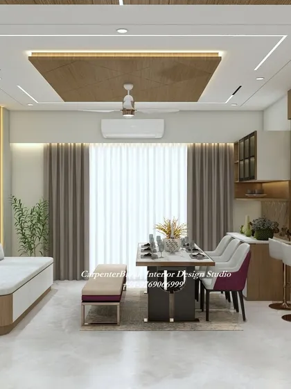 This dining area includes a stylish bar counter, making it a great space for entertaining. The wooden false ceiling adds warmth and texture.