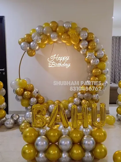 A grand gold and silver balloon ring with star-topped pillars and foil letter balloons for the name.
