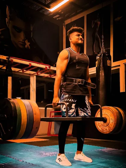 Building a powerful fighter starts with a strong foundation. A member performs a heavy trap bar deadlift, utilizing our fully equipped gym to build overall strength and stability.