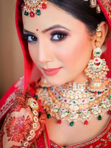 A close-up portrait with a direct gaze, perfect for showcasing the flawless bridal makeup and detailed accessories.