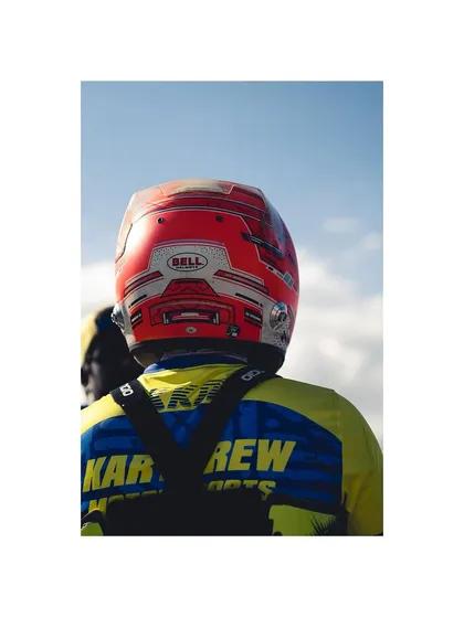 A close-up of a driver's helmet and our team's branding.