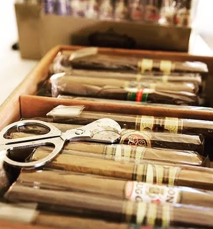 For a complete experience, I offer a curated selection of premium cigars. This close-up shows a humidor box with carefully arranged cigars and a cutter, adding an extra layer of luxury for your guests.