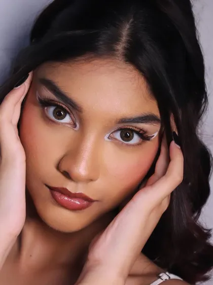 A classic beauty pose that highlights the symmetry and precision of the makeup application.