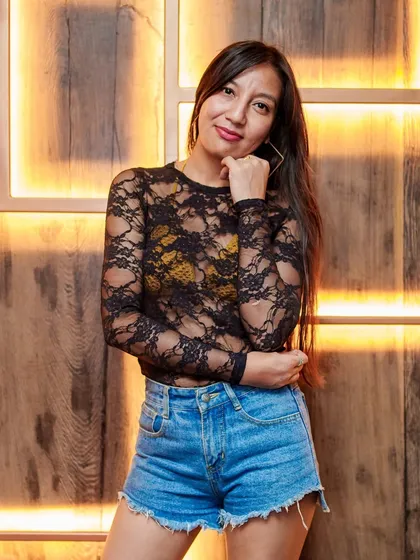 A guest posing against the wooden backdrop at Kaze. The venue has so many cool photo spots.