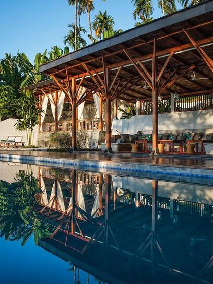 The reflection of the restaurant pavilion in the infinity pool, highlighting the harmony between the architecture and the water.