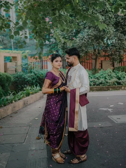 A classic portrait of a Maharashtrian couple. The groom's protective stance and the bride's confident gaze towards the camera create a powerful and timeless image of partnership.