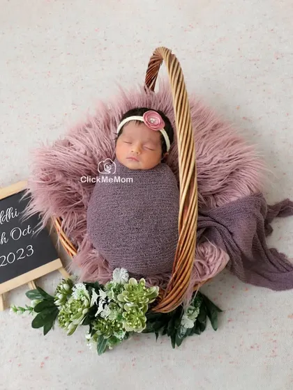 This portrait includes a personalized touch with a small chalkboard announcing the baby's name and birth date, making it a perfect birth announcement photo.