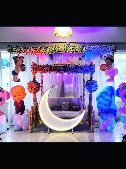 The mixed-character baby shower decor illuminated with blue and purple lights, creating a fun party atmosphere.