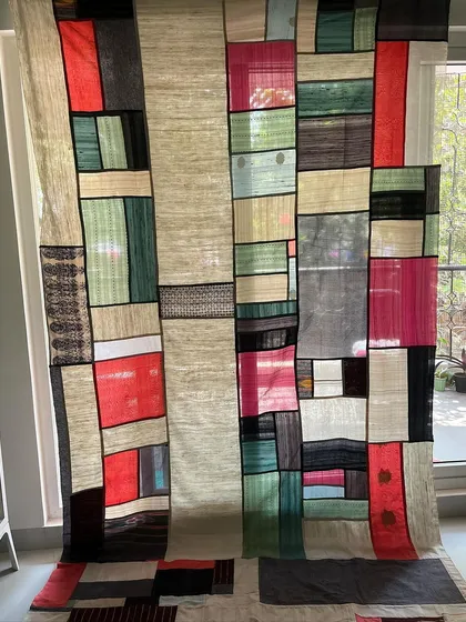 We can help you create large-scale, artistic pieces for your home. This Pojagi-style room divider was crafted from old sarees and dhotis, using transparent blocks to create a beautiful see-through effect.