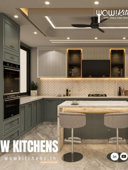 Another angle of this luxurious sage green kitchen, highlighting the built-in ovens and the seamless integration of the cabinetry with the architecture of the room.