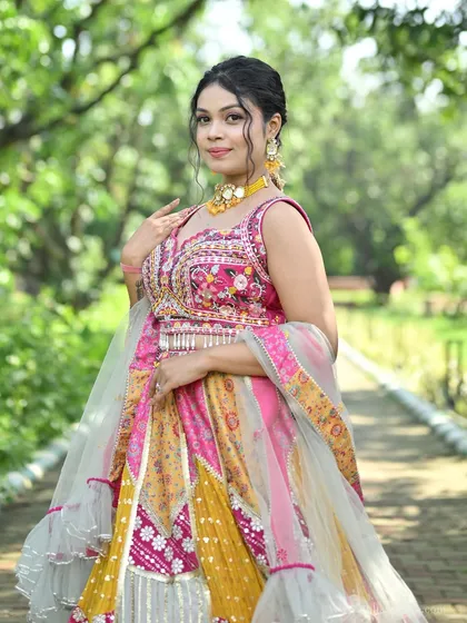 A close-up of a model wearing the pink and yellow patchwork lehenga, highlighting the vibrant colors and detailed craftsmanship.