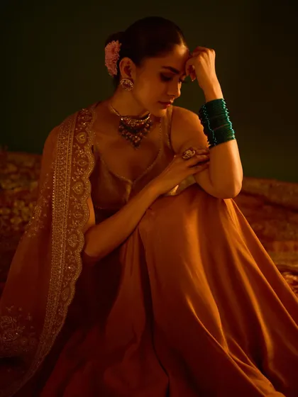 A quiet, artistic shot that feels intimate and captures the rich, warm tones of the outfit.