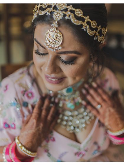 A close-up of the bride admiring her stunning necklace. We focus on the details that make her bridal look unique.