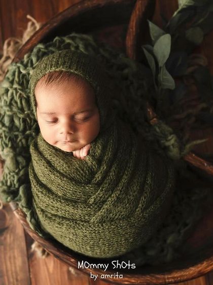 A top-down view of a newborn in a moon-shaped wooden bowl, showcasing how different angles can transform a prop setup.