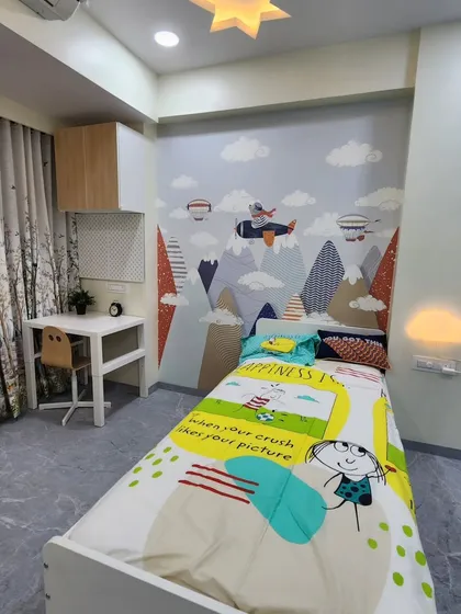 Another angle of the kids' room, showing the bed with its colorful bedding and the imaginative wall decor.