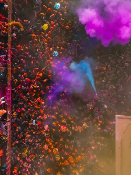 A cloud of purple smoke rises from the crowd. Flying a drone in these conditions is risky, with colors and water everywhere, but it's the only way to get these immersive shots.