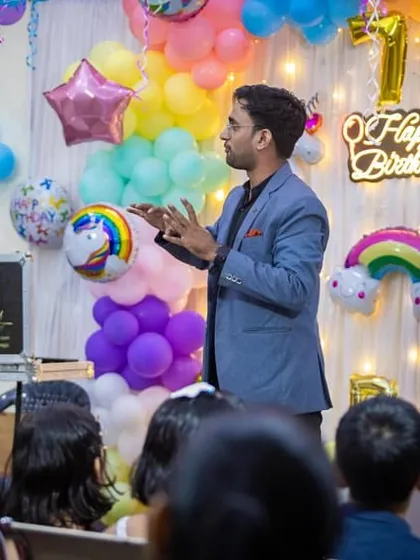 Explaining a trick to the parents at a birthday party. It's important that everyone feels included in the fun.