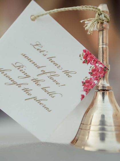 "Let's hear the sound of love! Ring the bells through the pheras." A thoughtful detail, providing guests with bells to celebrate the couple's union.