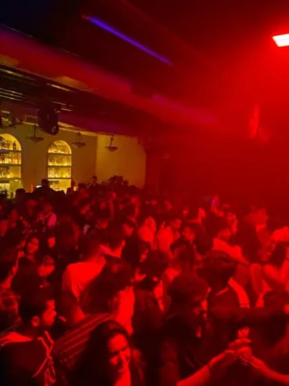 The dancefloor under the red lights, completely full. I read the room and play the tracks that keep everyone on their feet.