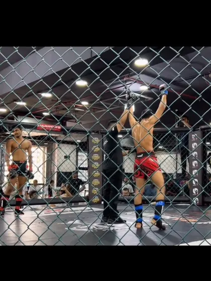 A view from outside the cage as our fighter celebrates his victory. This perspective shows the intense atmosphere of a live MMA event.