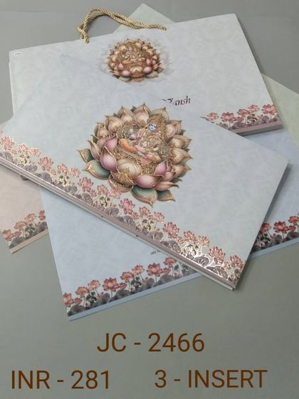 This invitation set is adorned with a beautiful illustration of a goddess seated on a lotus. The design is serene and auspicious, and it comes with a matching carry bag.