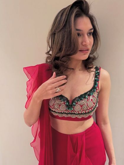 A guest trying on a stunning red ensemble at the Ridhi Mehra collection preview. I create an environment where attendees can interact with the product and feel like part of an exclusive experience.
