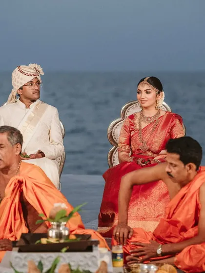 The couple during their serene beachside wedding ceremony. The open-air mandap allows the natural beauty of the ocean to become a part of their special moment.