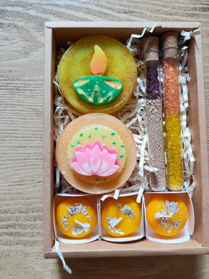 A premium Diwali slider box with two types of saffron milk soaps, ubtan and bath salt tubes, and handmade peda-shaped candles.