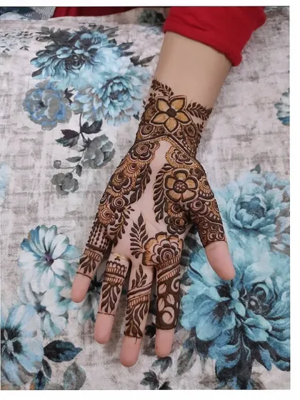 A beautiful floral design on the back of the hand, featuring a mix of bold flowers and delicate leafy vines.