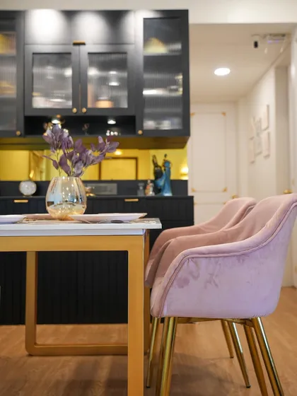 A close-up of the dining chairs and bar unit, highlighting the mix of plush textures and sleek finishes in this Bridgerton-inspired home.