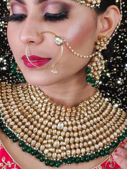 A close-up of a heavy Kundan choker with green bead drops. The intricate design and quality of the stones are clearly visible.