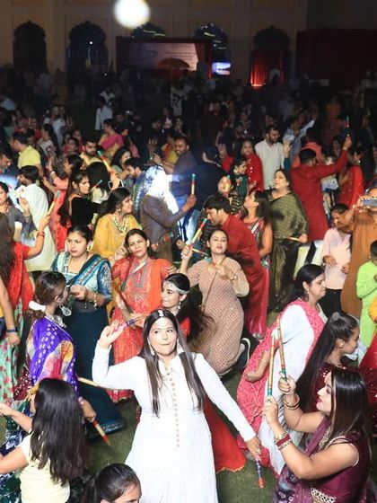 The joy of dancing together. A huge crowd of people of all ages enjoying the Dandiya night, with smiles on their faces.