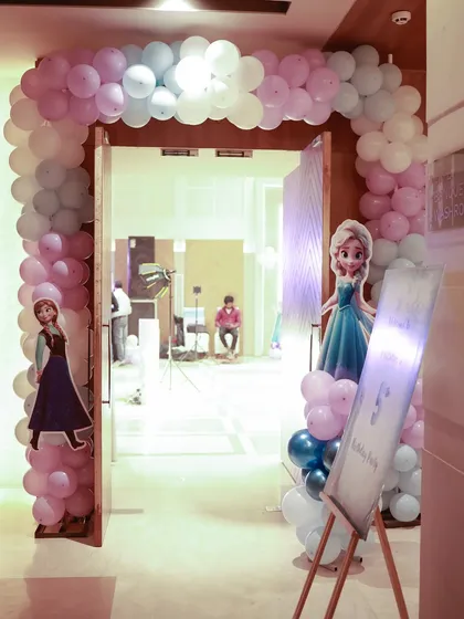 The entrance to the winter wonderland, with a balloon arch and cutouts of Elsa and Anna to welcome the little guests.