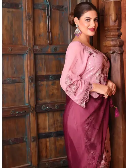 A three-quarter view against a rustic door, showing how the ethnic wear looks from a different angle and adding a touch of warmth to the shot.
