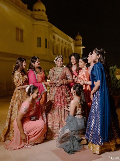 The bride, Aashi, sharing a laugh with her bridesmaids, a candid moment of friendship and support.