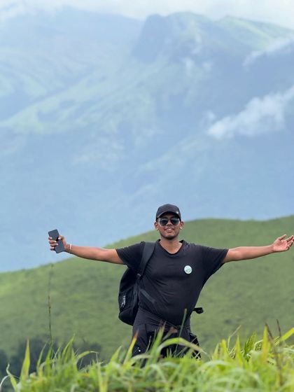A trekker with arms outstretched, celebrating the stunning views on the Bandaje trek.