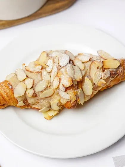 Another angle of the almond croissant, showing the texture of the pastry and the toasted almonds. Providing multiple views helps customers make a choice.