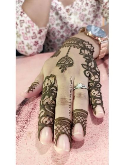 A close up of the finger details for the modern 'cutwork' design. The intricate floral patterns on the fingers complement the jhumki motif on the back of the hand.