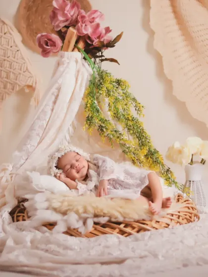 Another perspective of the floral teepee, showing the baby smiling in their sleep. We take multiple shots to capture these fleeting, precious expressions.