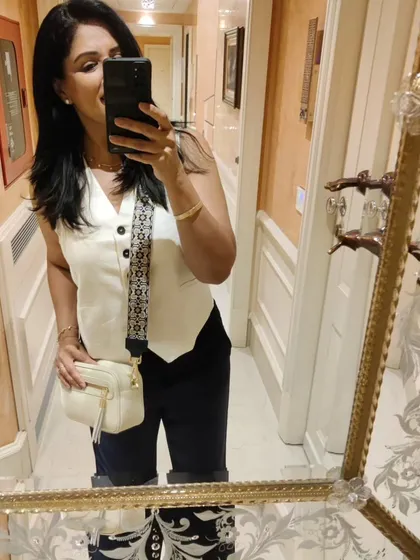 A mirror selfie showing my travel outfit in Venice: navy linen pants and a white waistcoat.