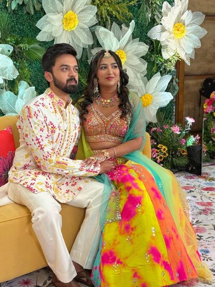 A vibrant and colorful sangeet look. The bride's multi-colored lehenga is complemented by makeup that is radiant and fun.