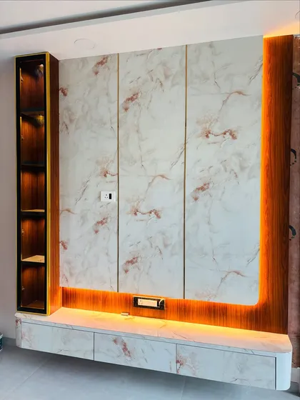 A full view of a floating TV unit with a high-gloss marble laminate finish. The design includes a vertical display cabinet with internal lighting and warm ambient light from underneath the console.